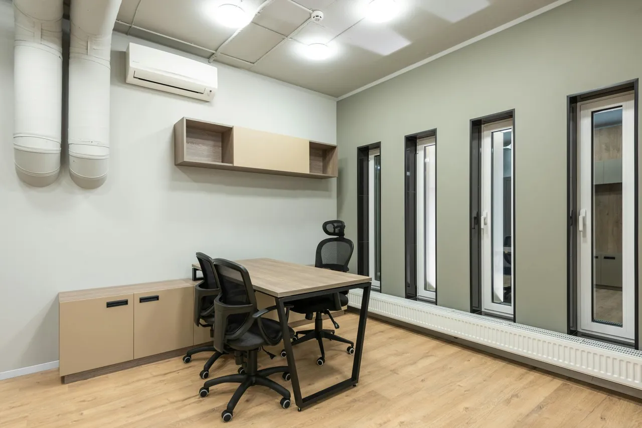 A modern ergonomic home office setup with a person stretching, alongside a serene bedroom scene, emphasizing the connection between a healthy daily environment and restful sleep for pain management.